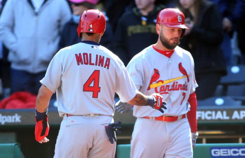 Apr 3, 2016; Pittsburgh, PA, USA; St. Louis Cardinals catcher Yadier Molina (4) is greeted by first baseman Matt Holliday (7) after Molina scored a run against the Pittsburgh Pirates during the ninth inning at PNC Park. The Pirates won 4-1. Mandatory Credit: Charles LeClaire-USA TODAY Sports