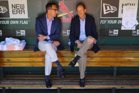 John Mozeliak (L) and Bill DeWitt, Jr. managing partner and chairman of the St. Louis Cardinals talk in the dugout prior to a game against the Chicago Cubs. (Photo by Dilip Vishwanat/Getty Images)