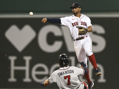 BOSTON, MASSACHUSETTS – AUGUST 10: Xander Bogaerts #2 of the Boston Red Sox throws to first base over Dansby Swanson #7 (Photo by Brian Fluharty/Getty Images)