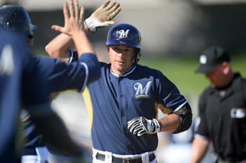 Mar 10, 2014; Phoenix, AZ, USA; Milwaukee Brewers catcher Adam Weisenburger (71) slaps hands with teammates after hitting a two-run home run in the eighth inning against the Chicago White Sox at Maryvale Baseball Park. Mandatory Credit: Joe Camporeale-USA TODAY Sports