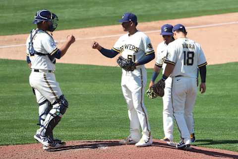 PHOENIX, ARIZONA – MARCH 21: Freddy Peralta #51 of the Milwaukee Brewers is greeted by teammates moments before exiting the game in the fifth inning against the Seattle Mariners during the MLB spring training game at American Family Fields of Phoenix on March 21, 2021 in Phoenix, Arizona. (Photo by Abbie Parr/Getty Images)