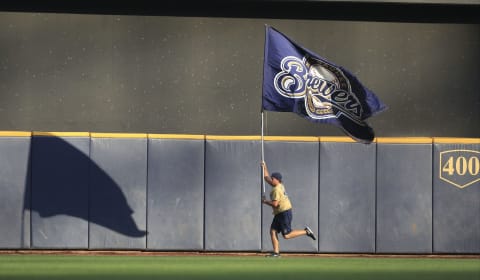 MILWAUKEE, WI – AUGUST 15: A Milwaukee Brewers fan runs through centerfield with a Brewers flag before the before their game against the Philadelphia Phillies at Miller Field on August 15, 2015 in Milwaukee, Wisconsin. The Brewers defeated the Phillies 4-2. (Photo by John Konstantaras/Getty Images)