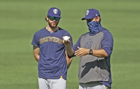 Jul 28, 2020; Pittsburgh, Pennsylvania, USA; Milwaukee Brewers relief pitcher Bobby Wahl (31) listens as bullpen coach Steve Karsay (right) demonstrates a pitching grip before playing the Pittsburgh Pirates at PNC Park. Mandatory Credit: Charles LeClaire-USA TODAY Sports