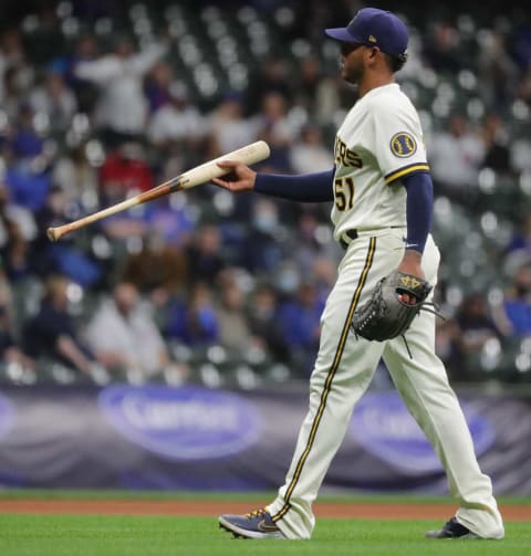 Brewers starter Freddy Peralta retrieves the bat of Chicago Cubs shortstop Javier Baez (not pictured) after Baez lost his grip on it while striking out during the fourth inning. Peralta struck out 10 hitters in six innings.Mlb Chicago Cubs At Milwaukee Brewers