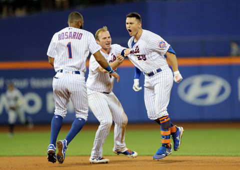 NEW YORK, NEW YORK – AUGUST 21: J.D. Davis #28 of the New York Mets celebrates his first career walk off single with teammates Amed Rosario #1 and Pete Alonso #20 in the 10th inning against the Cleveland Indians at Citi Field on August 21, 2019 in the Flushing neighborhood of the Queens borough of New York City.The New York Mets defeated the Cleveland Indians 4-3 in 10 innings. (Photo by Elsa/Getty Images)