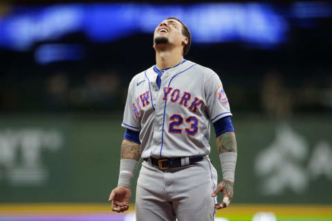 MILWAUKEE, WISCONSIN – SEPTEMBER 24: Javier Baez #23 of the New York Mets tries to catch rain drops leaking through the roof in the eighth inning against the Milwaukee Brewers at American Family Field on September 24, 2021 in Milwaukee, Wisconsin. (Photo by John Fisher/Getty Images)