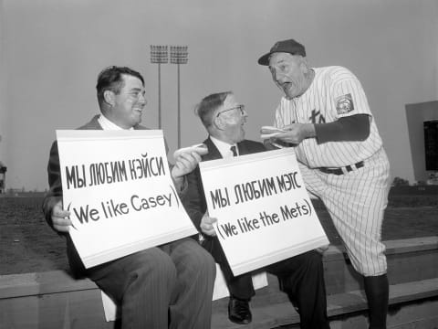 FLUSHING, NY – 1964 : Manager Casey Stengel of the New York Mets hams it up with foreign fans of the Mets while introducing them to a ballpark staple, the hotdog prior to a 1964 season game at Shea Stadium in Flushing, New York. (Photo by: Olen Collection/Diamond Images/Getty Images)