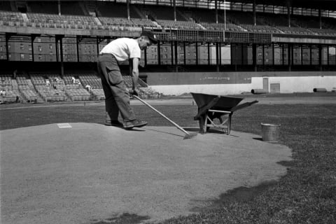 NEW YORK, NY – MARCH 29, 1962: A groundskeeper rakes the dirt on the pitchers mound as he helps to prepare the Polo Grounds on March 29, 1962 for the Opening Day game for the New York Mets in New York, New York. (Photo by: Kidwiler Collection/Diamond Images/Getty Images)