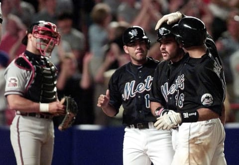 New York Mets catcher Mike Piazza (2nd R) is congratulated by teammates Edgardo Alfonso (L) and Derek Bell (R) after he drove the two men in with a three-run homer over the left field wall in the bottom of the eighth inning that put the Mets ahead 11-8 against the Atlanta Braves 30 June 2000 at Shea Stadium in Flushing, NY. The Mets scored 10 runs in the inning tieing a team record as they came from behind to beat the Braves 11-8.(ELECTRONIC IMAGE) AFP PHOTO/Matt CAMPBELL (Photo by MATT CAMPBELL / AFP) (Photo credit should read MATT CAMPBELL/AFP via Getty Images)