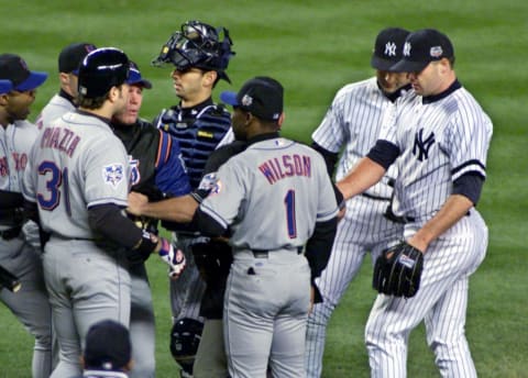 New York Yankees and New York Mets players confront one another on the field after Yankees pitcher Roger Clemens (R) threw a piece of broken bat at Mets catcher Mike Piazza (L front) as he ran to first base during the first inning of the Second Game of the World Seriesat Yankee Stadium in New York City 22 October 2000. AFP PHOTO/Don EMMERT (Photo by Don EMMERT / AFP) (Photo credit should read DON EMMERT/AFP via Getty Images)