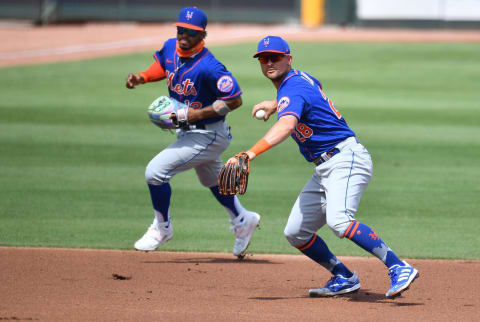 JUPITER, FLORIDA – MARCH 01: J.D. Davis #28 of the New York Mets makes a throw to first base as Francisco Lindor #12 of the New York Mets backs him up in the second inning against the Miami Marlins in a spring training game at Roger Dean Chevrolet Stadium on March 01, 2021 in Jupiter, Florida. (Photo by Mark Brown/Getty Images)