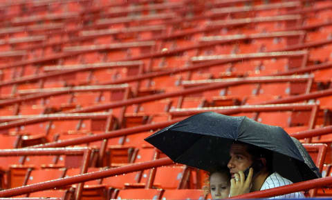 NEW YORK – MAY 16: A fan of the New York Mets talks on his phone during a rain delay before the game against the Chicago Cubs on May 16, 2007 at Shea Stadium in the Flushing neighborhood of the Queens borough of New York City. (Photo by Jim McIsaac/Getty Images)