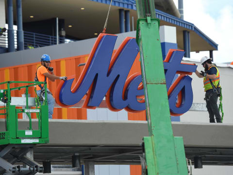 Construction crewmen work to install the New York Mets logo on top of a new entryway to the stadium on Tuesday, Feb. 18, 2020, as part of the renovations being completed at Clover Park in Port St. Lucie. Workers were seen installing seats, pouring concrete on the outside walkways, and adding signage around the stadium as the team works out on the backfields during the start of spring training.Tcn Mets A1 04