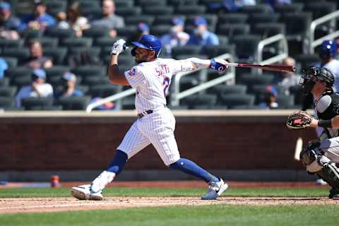 Apr 8, 2021; New York City, New York, USA; New York Mets left fielder Dominic Smith (2) follows through on a sacrifice fly against the Miami Marlins during the fifth inning of an opening day game at Citi Field. Mandatory Credit: Brad Penner-USA TODAY Sports