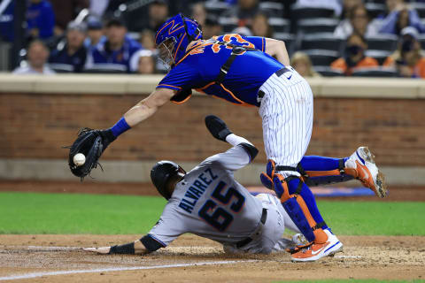 Sep 30, 2021; New York City, New York, USA; Miami Marlins shortstop Eddy Alvarez (65) scores a run against New York Mets catcher James McCann (33) during the fourth inning at Citi Field. Mandatory Credit: Vincent Carchietta-USA TODAY Sports