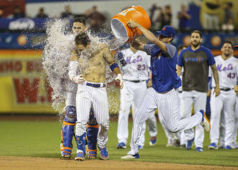 Aug 9, 2019; New York City, NY, USA; New York Mets center fielder Michael Conforto (30) is doused with water after hitting a walk off RBI single to beat the Washington Nationals 7-6 at Citi Field. Mandatory Credit: Wendell Cruz-USA TODAY Sports