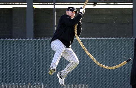 Rockies pitcher Aaron Cook swings from a rope.