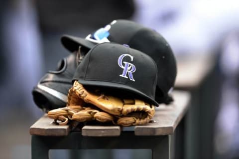 Colorado Rockies hats and gloves at Coors Field. The Rockies defeated the Cubs 5-1. Mandatory Credit: Ron Chenoy-USA TODAY Sports