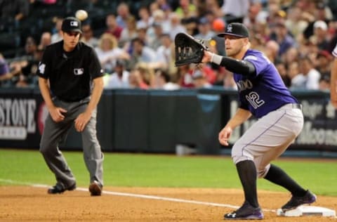 Apr 6, 2016; Phoenix, AZ, USA; Colorado Rockies third baseman Mark Reynolds (12) catches a ball for an out in the fourth inning against the Arizona Diamondbacks at Chase Field. Mandatory Credit: Matt Kartozian-USA TODAY Sports