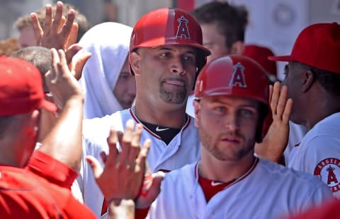 Jun 24, 2015; Anaheim, CA, USA; Los Angeles Angels first baseman Albert Pujols (5) is greeted in the dugout after scoring a run on a sacrifice fly by catcher Chris Iannetta (not pictured) in the fourth inning of the game at Angel Stadium of Anaheim. Mandatory Credit: Jayne Kamin-Oncea-USA TODAY Sports