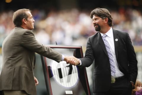 Aug 17, 2014; Denver, CO, USA; Former Colorado Rockies first baseman Todd Helton (right) shakes hands with team owner Dick Monfront (left) during a ceremony to retire Helton