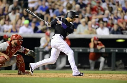 Jul 7, 2016; Denver, CO, USA; Colorado Rockies right fielder Carlos Gonzalez (5) singles in the seventh inning against the Philadelphia Phillies at Coors Field. The Rockies defeated the Phillies 11-2. Mandatory Credit: Ron Chenoy-USA TODAY Sports