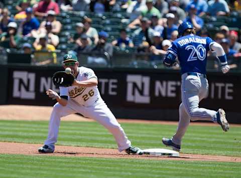 Jul 17, 2016; Oakland, CA, USA; Toronto Blue Jays third baseman Josh Donaldson (20) safe at first base against Oakland Athletics first baseman Danny Valencia (26) during the first inning at O.co Coliseum. Mandatory Credit: Kelley L Cox-USA TODAY Sports