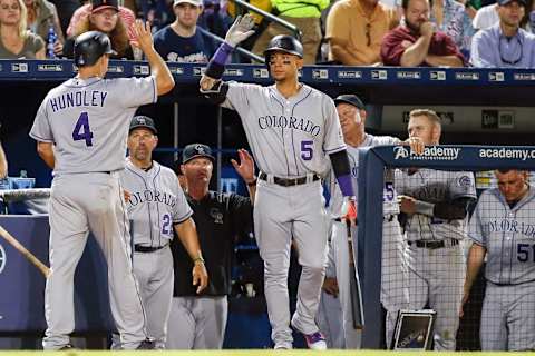 Jul 16, 2016; Atlanta, GA, USA; Colorado Rockies catcher Nick Hundley (4) is congratulated by right fielder Carlos Gonzalez (5) after scoring a run against the Atlanta Braves in the eighth inning at Turner Field. Mandatory Credit: Brett Davis-USA TODAY Sports