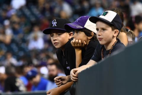 Aug 3, 2016; Denver, CO, USA; Colorado Rockies fans hang over a wall during a break in the in the fifth inning of the game against the Los Angeles Dodgers at Coors Field. Mandatory Credit: Ron Chenoy-USA TODAY Sports