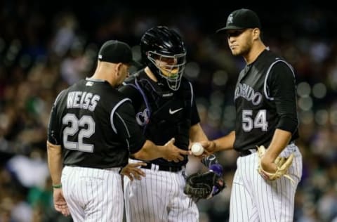 Aug 5, 2016; Denver, CO, USA; Colorado Rockies catcher Nick Hundley (4) watches as relief pitcher Carlos Estevez (54) hands the ball off to manager Walt Weiss (22) in the ninth inning against the Miami Marlins at Coors Field. Mandatory Credit: Isaiah J. Downing-USA TODAY Sports