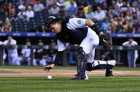 Sep 20, 2016; Denver, CO, USA; Colorado Rockies catcher Tony Wolters (14) attempts to pick up wild pitch rebound in the first inning against the St. Louis Cardinals at Coors Field. Mandatory Credit: Ron Chenoy-USA TODAY Sports