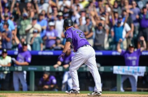 DENVER, CO – AUGUST 12: Chris Iannetta #22 of the Colorado Rockies walks to first base on a bases-loaded walk-off walk as teammates and fans react in the bottom of the ninth inning of a game against the Los Angeles Dodgers at Coors Field on August 12, 2018 in Denver, Colorado. (Photo by Dustin Bradford/Getty Images)