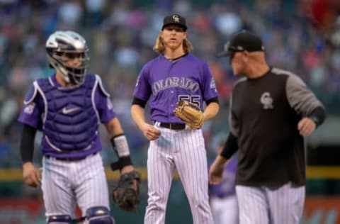 DENVER, CO – SEPTEMBER 29: Jon Gray #55 of the Colorado Rockies prepares to pitch after a mound visit from Tony Wolters #14 and pitching coach Steve Foster #36 in the first inning of a game against the Washington Nationals at Coors Field on September 29, 2018 in Denver, Colorado. (Photo by Dustin Bradford/Getty Images)