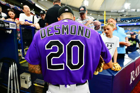 ST PETERSBURG, FLORIDA – APRIL 02: Ian Desmond #20 of the Colorado Rockies signs autographs for fans before a game against the Tampa Bay Rays at Tropicana Field on April 02, 2019 in St Petersburg, Florida. (Photo by Julio Aguilar/Getty Images)