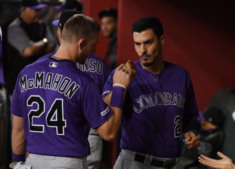 PHOENIX, ARIZONA – AUGUST 20: Nolan Arenado #28 of the Colorado Rockies prepares for a game with Ryan McMahon #24 in the dugout to a game against the Arizona Diamondbacks at Chase Field on August 20, 2019 in Phoenix, Arizona. Arenado was playing in his 1000th MLB game.(Photo by Norm Hall/Getty Images)