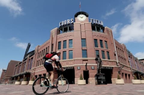 DENVER, COLORADO, – MARCH 26: People cycle in front of Coors Field on what was to be opening day for Major League Baseball on March 26, 2020 in Denver, Colorado. Major League Baseball has postponed the start of its season indefinitely due to the coronavirus (COVID-19) outbreak. (Photo by Matthew Stockman/Getty Images)