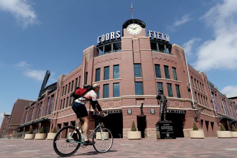 DENVER, COLORADO, – MARCH 26: People cycle in front of Coors Field on what was to be opening day for Major League Baseball on March 26, 2020 in Denver, Colorado. Major League Baseball has postponed the start of its season indefinitely due to the coronavirus (COVID-19) outbreak. (Photo by Matthew Stockman/Getty Images)