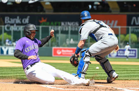 DENVER, CO - APRIL 10: Ryan McMahon #24 of the Colorado Rockies slides across home plate for a first inning run as Will Smith #16 of the Los Angeles Dodgers waits for the throw during a game at Coors Field on April 10, 2022 in Denver, Colorado. (Photo by Dustin Bradford/Getty Images)