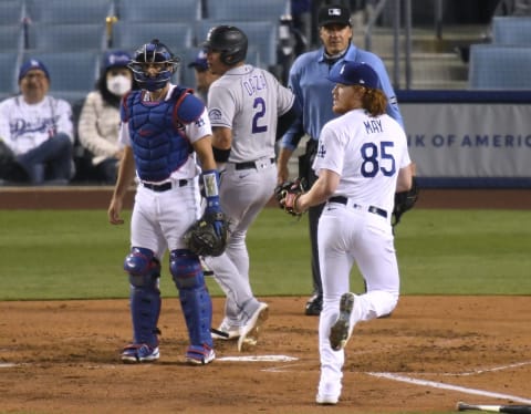 LOS ANGELES, CALIFORNIA – APRIL 14: Dustin May #85 and Austin Barnes #15 of the Los Angeles Dodgers react to a Trevor Story #27 of the Colorado Rockies single, to score Yonathan Daza #2, to trail 3-1, during the fifth inning at Dodger Stadium on April 14, 2021 in Los Angeles, California. (Photo by Harry How/Getty Images)