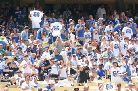 LOS ANGELES, CA – JULY 14: Fans hold up Yasiel Puig giveaway tee shirts after Puig #66 of the Los Angeles Dodgers got a pinch hit single in the fifth inning against the Colorado Rockies at Dodger Stadium on July 14, 2013 in Los Angeles, California. (Photo by Stephen Dunn/Getty Images)