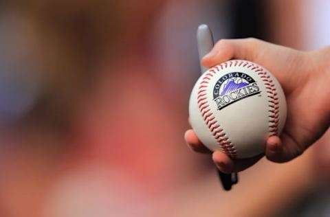 DENVER, CO – JULY 27: A young fan holds a baseball hoping to get an autograph as the Milwaukee Brewers face the Colorado Rockies at Coors Field on July 27, 2013 in Denver, Colorado. (Photo by Doug Pensinger/Getty Images)