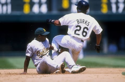 28 Jun 1998: Miguel Tejada #4 of the Oakland Athletics attempts to tag Ellis Burks #26 of the Colorado Rockies out during an interleague game at Coors Field in Denver, Colorado. The Rockies defeated the Athletics 11-10. Mandatory Credit: Brian Bahr /All