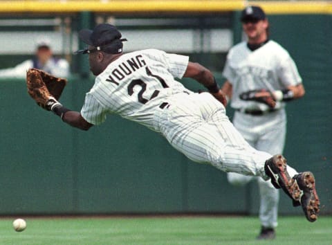 DENVER, CO – AUGUST 17: Colorado Rockies second baseman Eric Young leaps for a short pop fly to shallow centerfield from New York Mets player Luis Lopez as rightfielder Larry Walker (rear) looks on during their game 17 August at Coors Field in Denver, CO. Young was shaken up on the play as Lopez got a double. (Photo credit should read DOUG COLLIER/AFP via Getty Images)