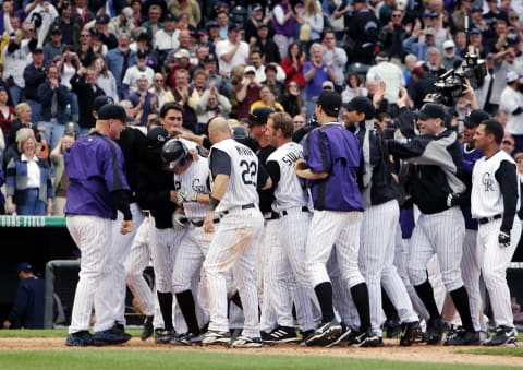 DENVER – APRIL 4: Clint Barmes #12 of the Colorado Rockies is swarmed by his teammates after hitting a walk-off game-winning home run against the San Diego Padres in the bottom of the ninth inning at Coors Field on opening day on April 4, 2005 in Denver, Colorado. The Rockies won 12-10. (Photo by Brian Bahr/Getty Images)