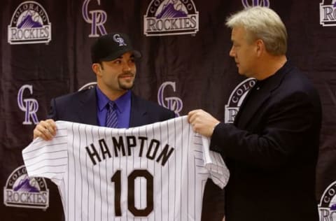 09 Dec 2000: Pitcher Mike Hampton holds up his Colorado Rockies jersey and dons the team cap with the help of manager Buddy Bell during a press conference at Coors Field in Denver, Colorado. Hampton, a free agent, was signed away from the New York Mets for more than 123 million dollars over eight years. Mandatory Credit: Brian Bahr/ALLSPORT