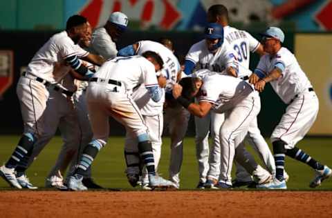 ARLINGTON, TX – JUNE 17: Jose Trevino #71 of the Texas Rangers is mobbed by teammates after he hit a game winning two-run single against the Colorado Rockies in the bottom of the ninth inning at Globe Life Park in Arlington on June 17, 2018 in Arlington, Texas. The Rangers won 13-12. (Photo by Ron Jenkins/Getty Images)