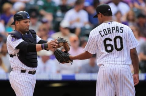 DENVER, CO – AUGUST 11: Catcher Yorvit Torrealba #8 of the Colorado Rockies gives the ball to relief pitcher Manny Corpas #60 of the Colorado Rockies as they work against the Pittsburgh Pirates in the seventh inning at Coors Field on August 11, 2013 in Denver, Colorado. Corpas earned the win as the Rockies defeated the Pirates 3-2. (Photo by Doug Pensinger/Getty Images)