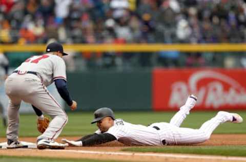 DENVER, CO – APRIL 06: Carlos Gonzalez #5 of the Colorado Rockies beats the tag of third baseman Ryan Flaherty #27 of the Atlanta Braves for a RBI triple in the first inning at Coors Field on April 6, 2018 in Denver, Colorado. (Photo by Matthew Stockman/Getty Images)