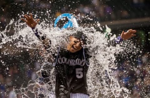 DENVER, CO – SEPTEMBER 26: Carlos Gonzalez #5 of the Colorado Rockies is drenched by a teammate after hitting a walk-off 2-run home run to put the Rockies ahead of the Dodgers 8-6 at Coors Field on September 26, 2015 in Denver, Colorado. (Photo by Dustin Bradford/Getty Images)