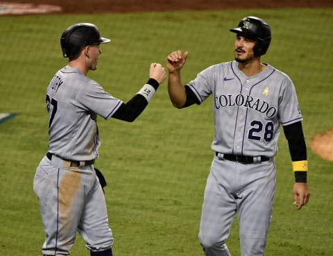 Sep 5, 2020; Los Angeles, California, USA; Colorado Rockies shortstop Trevor Story (27) and third baseman Nolan Arenado (28) celebrate scoring on pinch hitter Josh Fuentes (not pictured) double in the ninth inning against the Los Angeles Dodgers at Dodger Stadium. Mandatory Credit: Robert Hanashiro-USA TODAY Sports